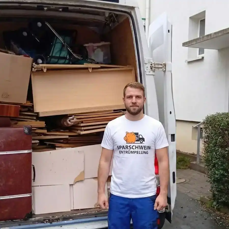 Entrümpler vor vollbeladenem Transporter bei einer Wohnungsentrümpelung